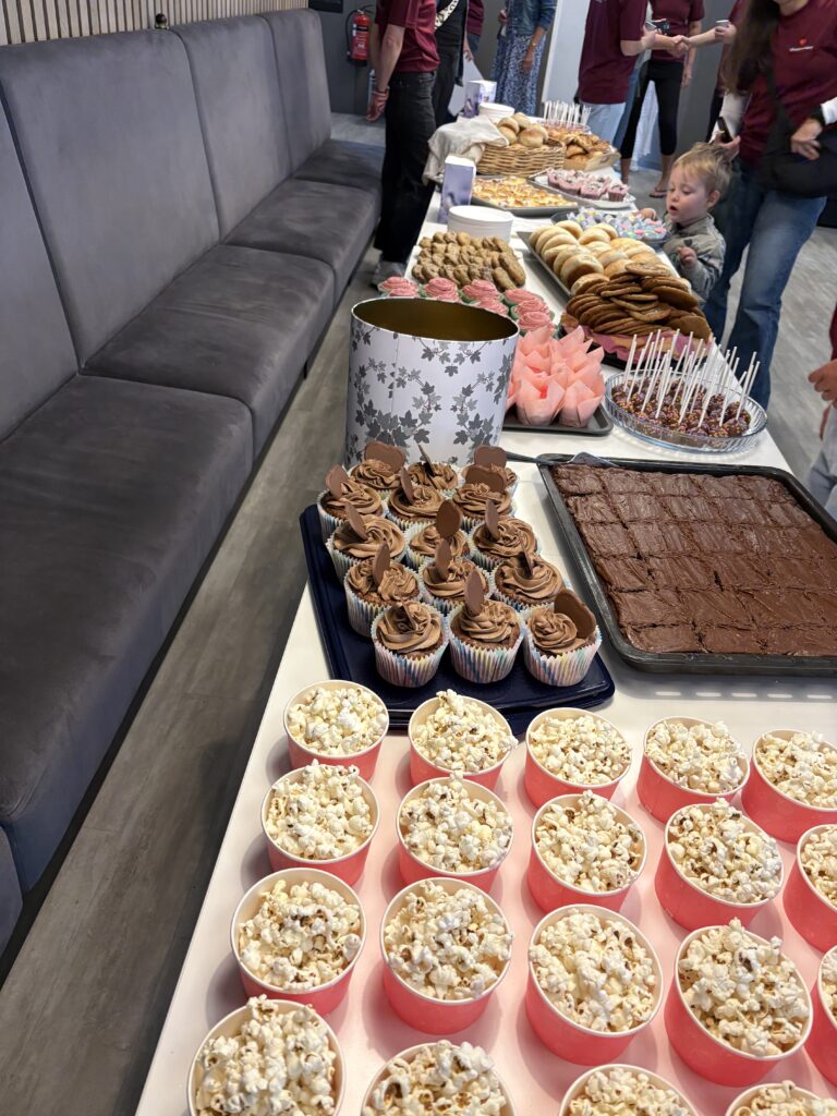 Et langt bord er dekket med cupcakes, kaker og annen bakst.