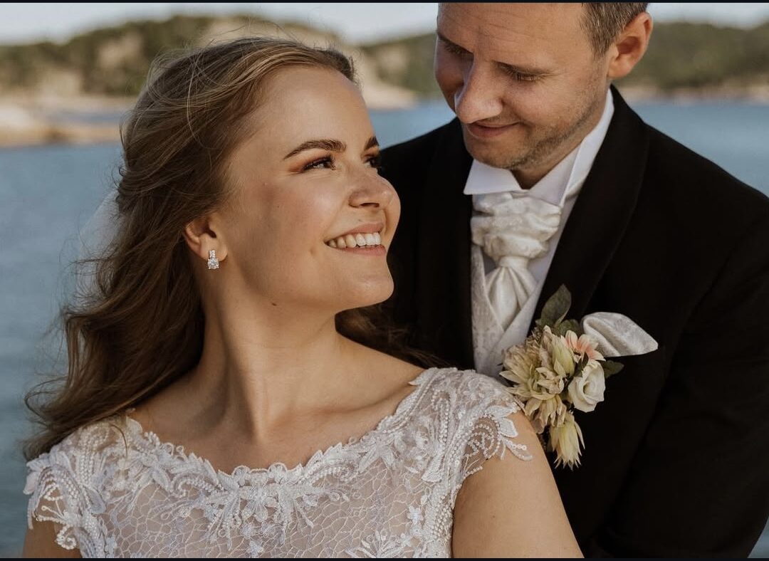 Christina smiler på bryllupsdagen, med Christoffer tett ved siden av seg.